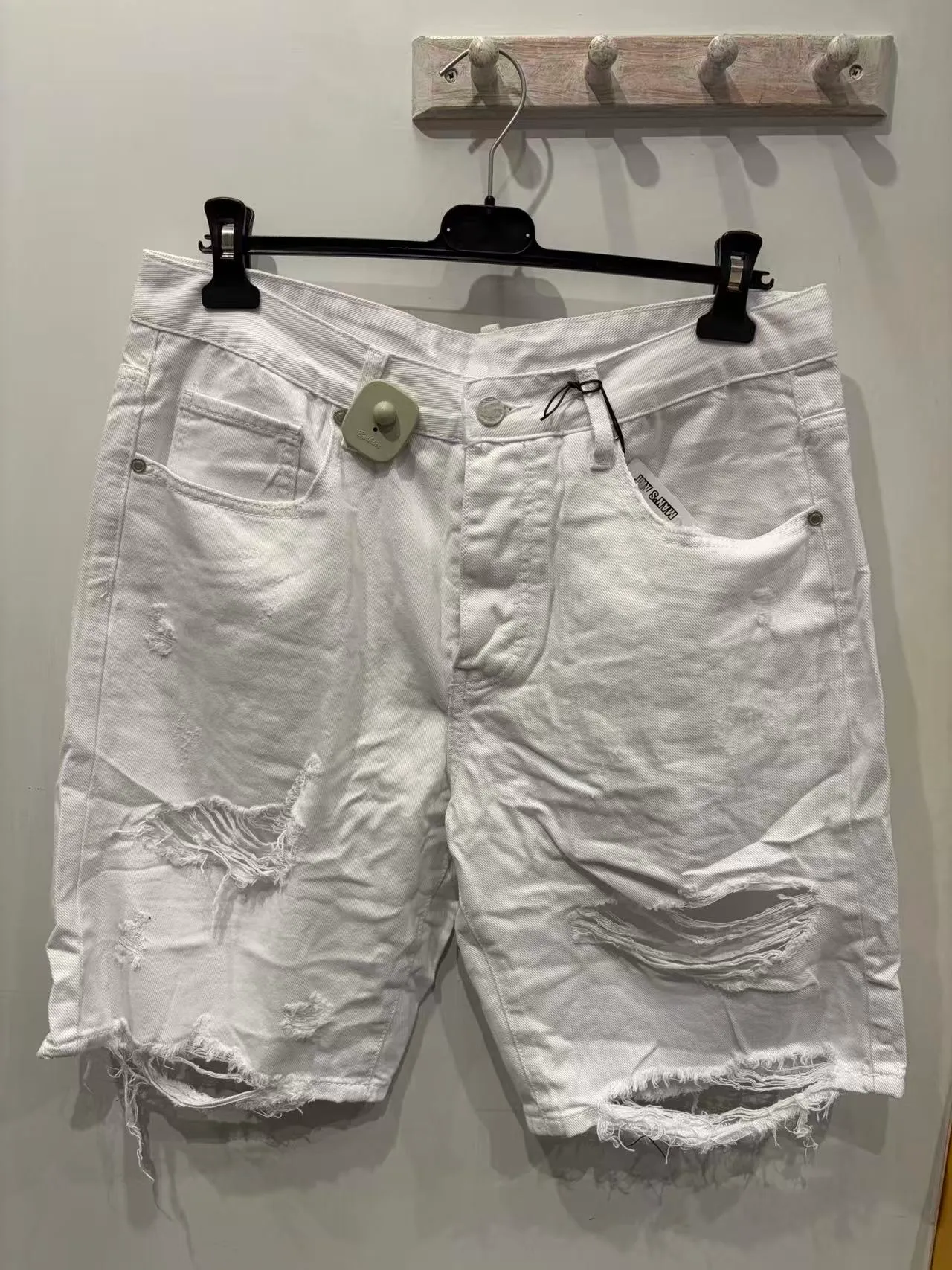 Pantaloncini bianchi stile denim con strappi e bordi sfrangiati, vista frontale