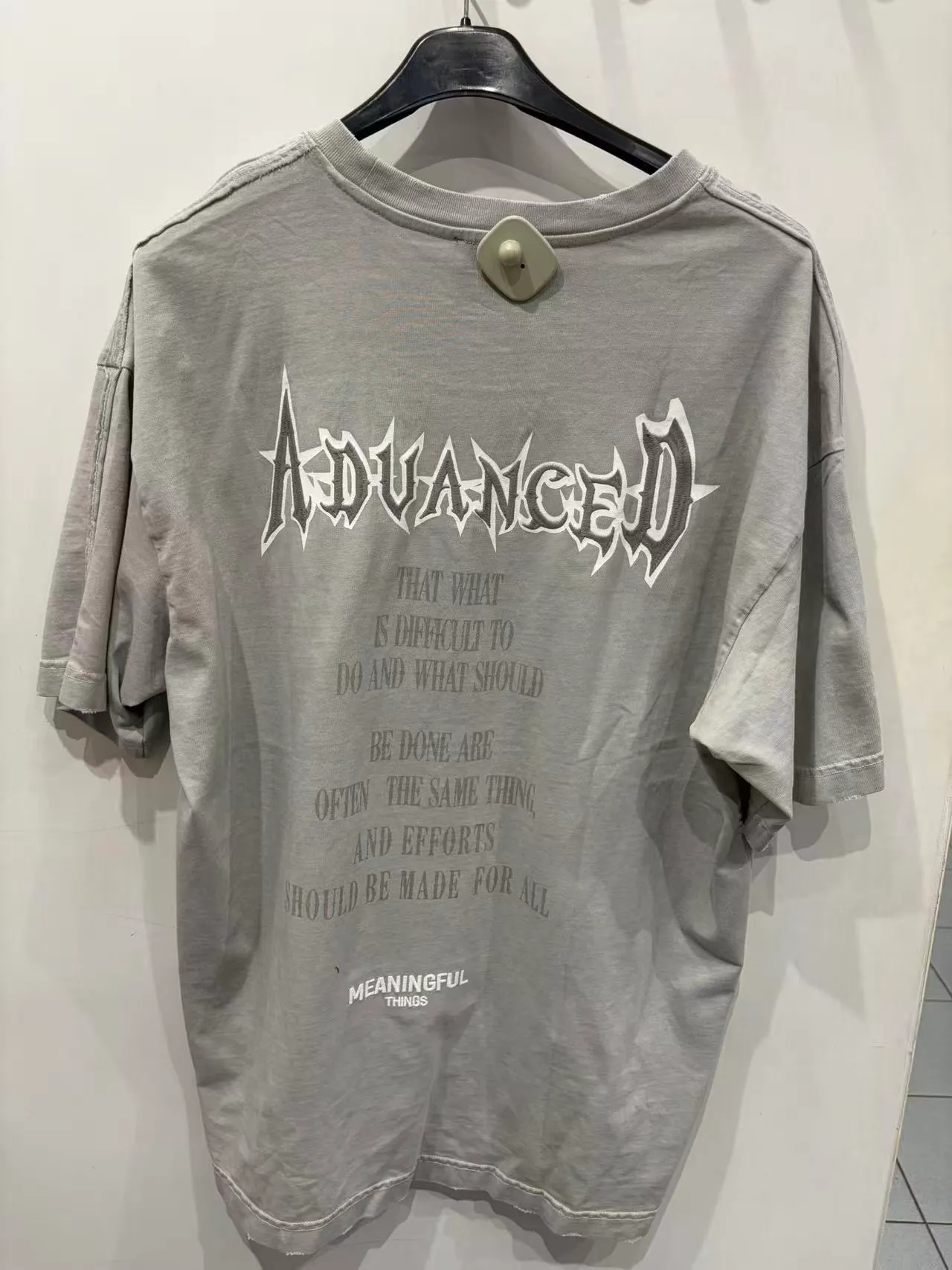 T-shirt grigia con grafica tipografica bianca, vista frontale