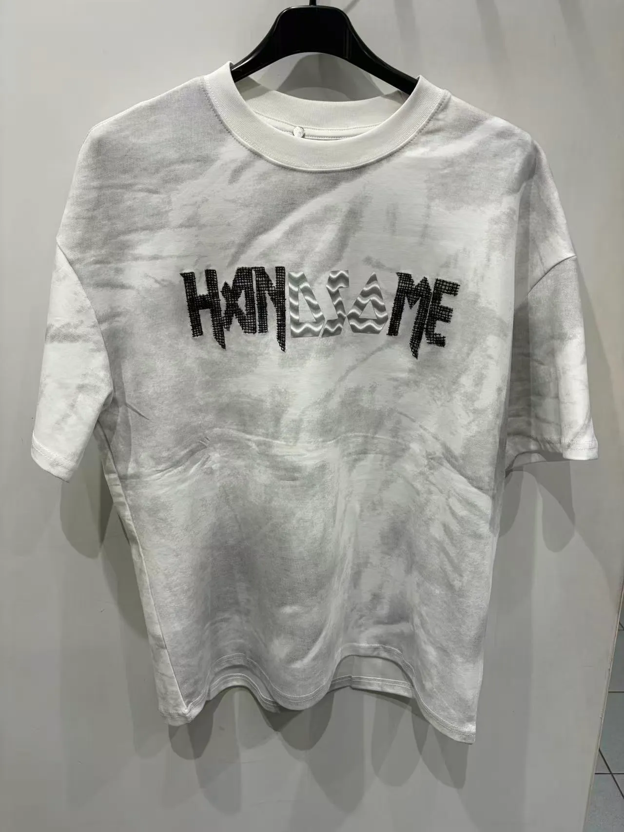 T-shirt bianca oversize con stampa grafica nera, vista frontale